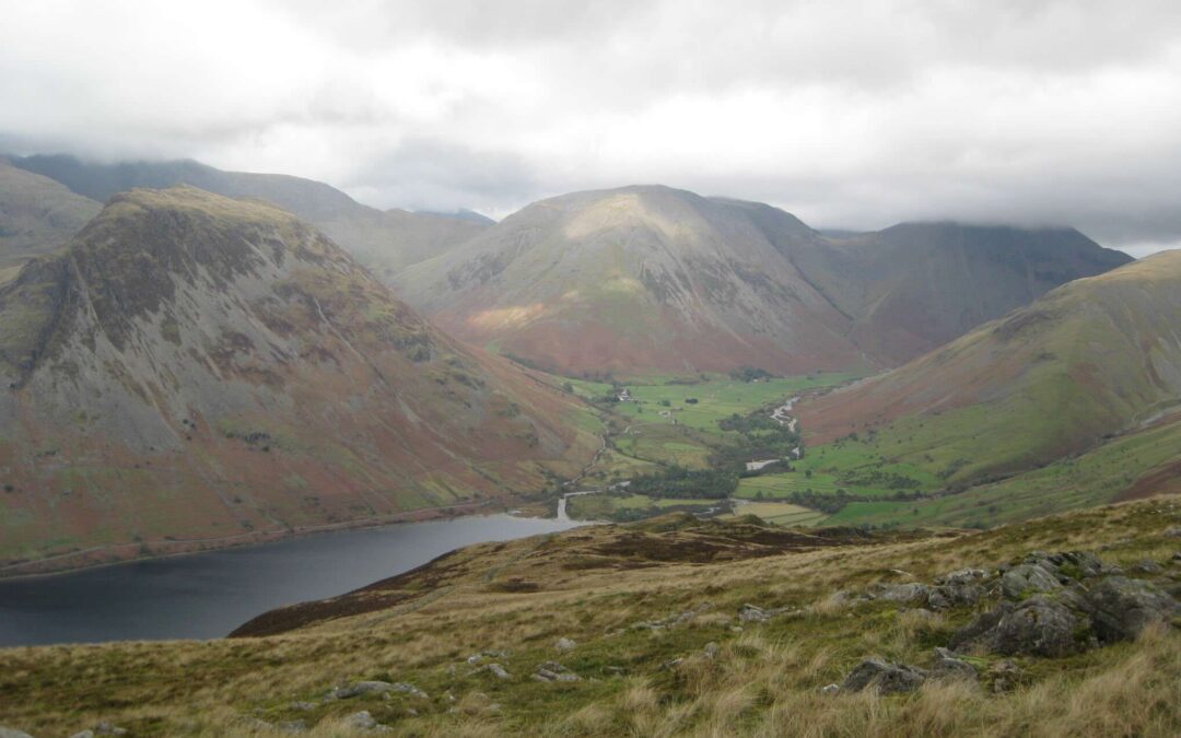 A landscape showing a distant view of a lake among mountains